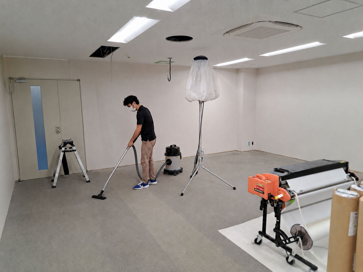 クロス施工後の室内を清掃する作業員
